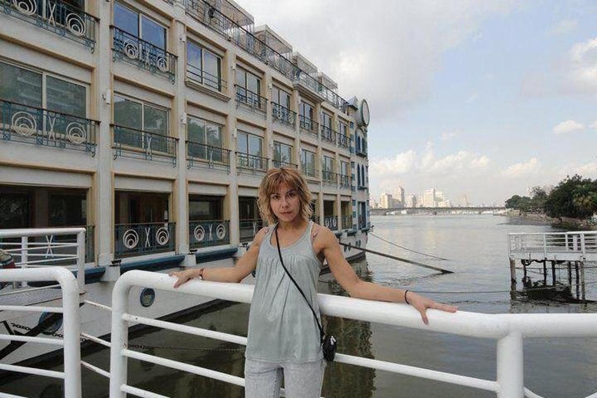una donna in piedi accanto a una ringhiera di fronte a un edificio