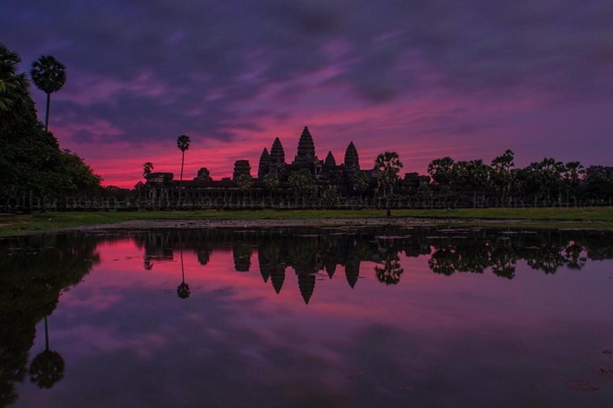 en solnedgang over et tempel med en refleksjon i vannet