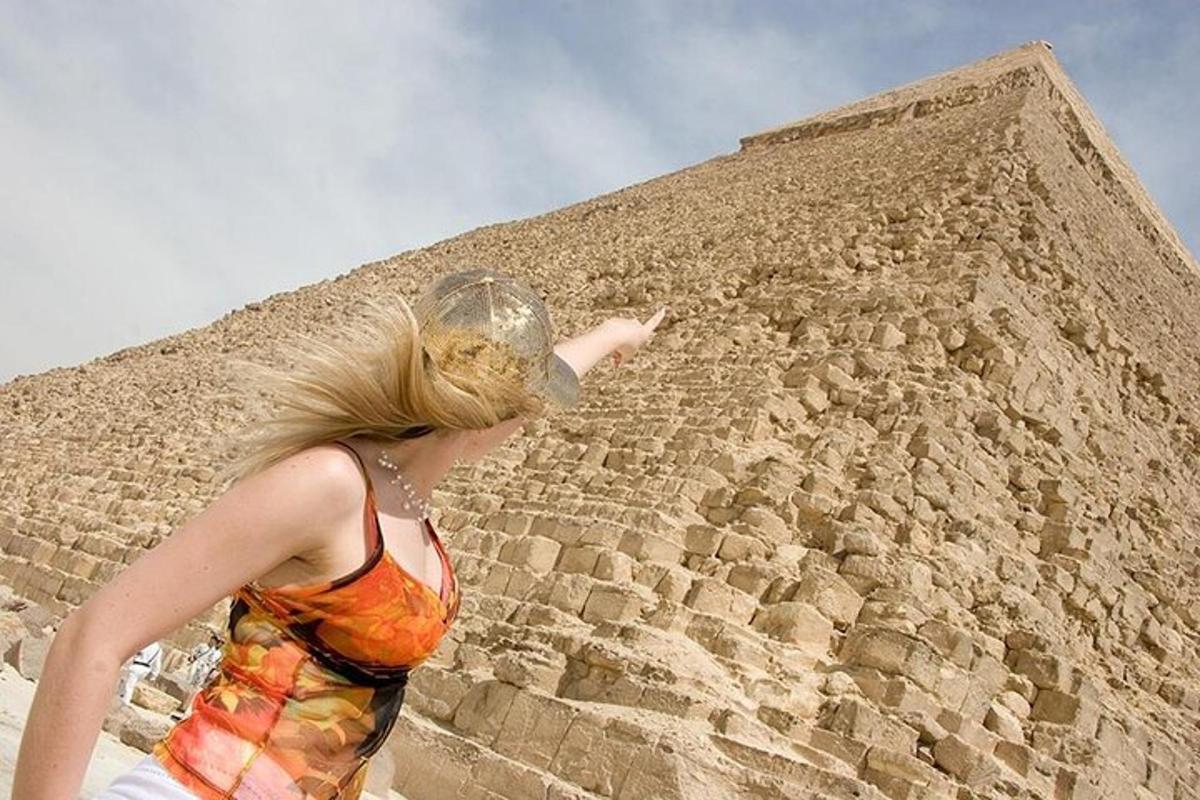 o femeie care stă în fața unei piramide