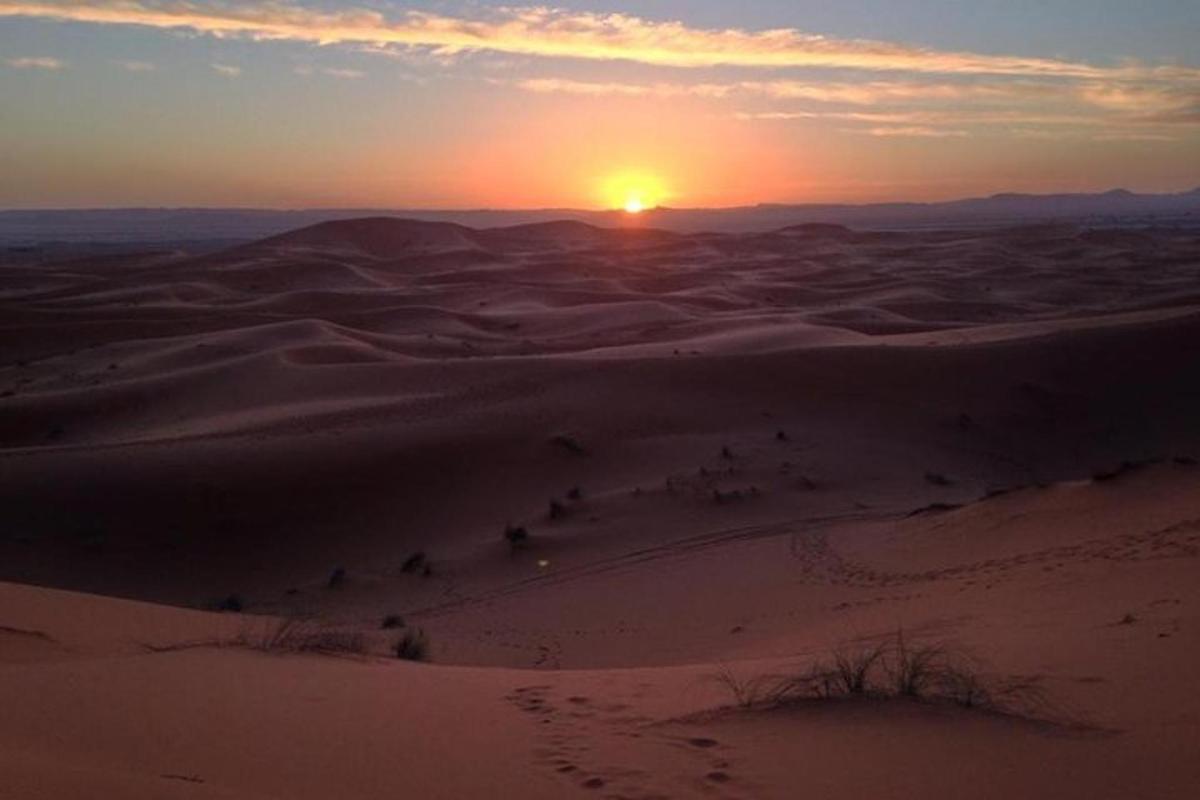 a sunset in the desert with the sun in the horizon