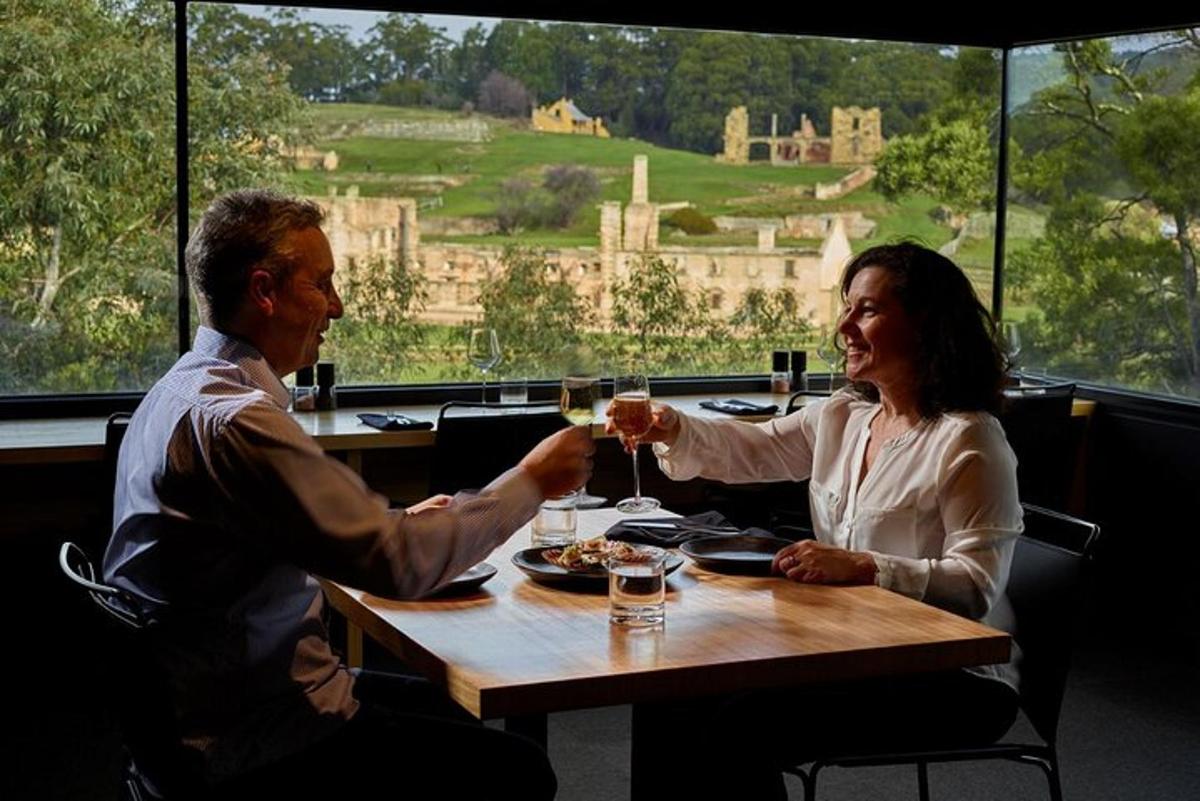 um homem e uma mulher sentados à mesa com taças de vinho