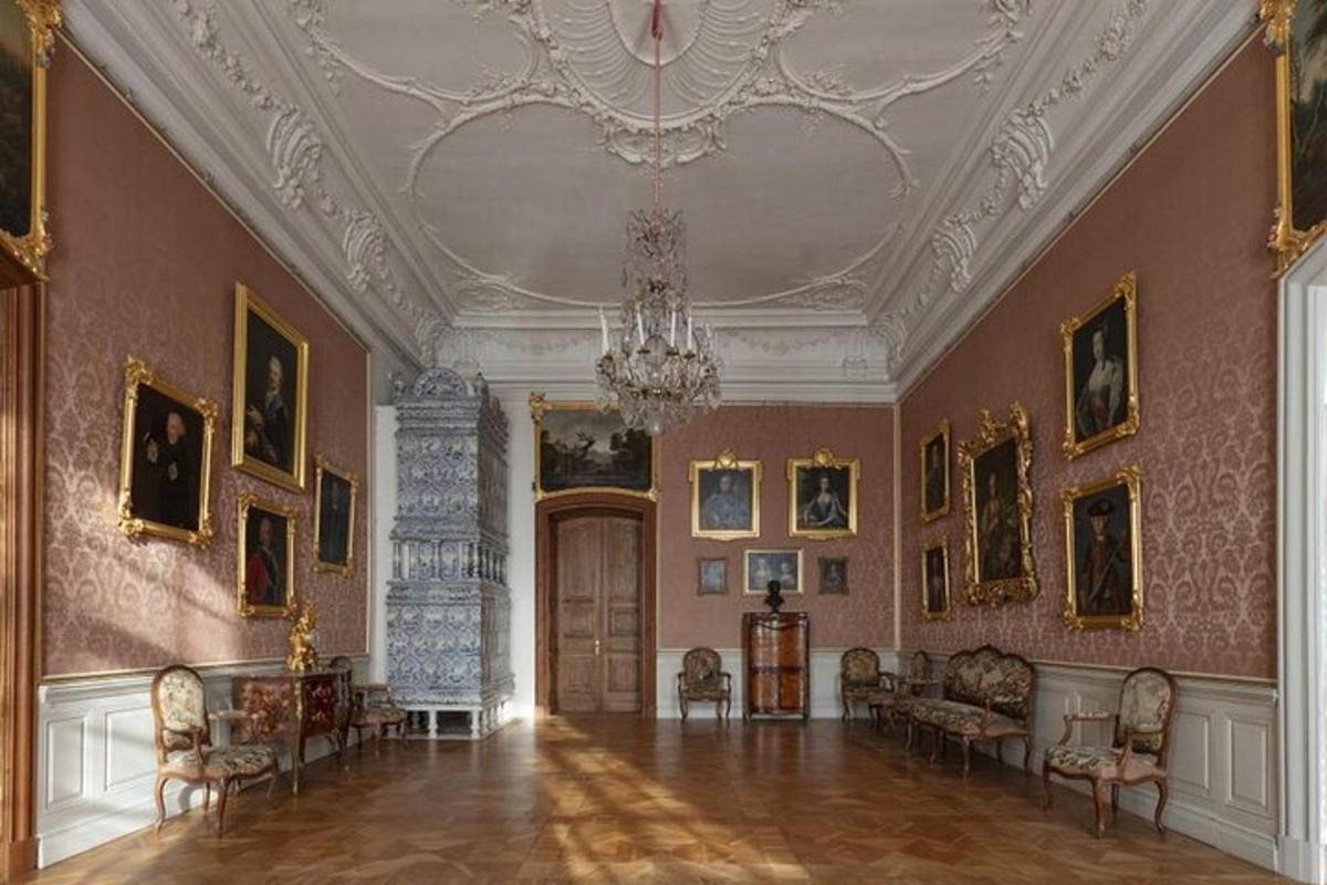 a living room with a chandelier and a room with paintings