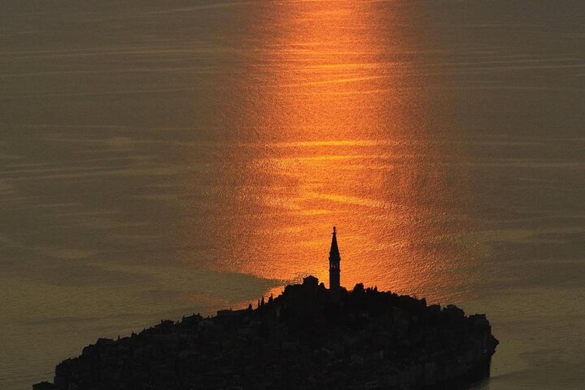 maják na ostrově v oceánu při západu slunce