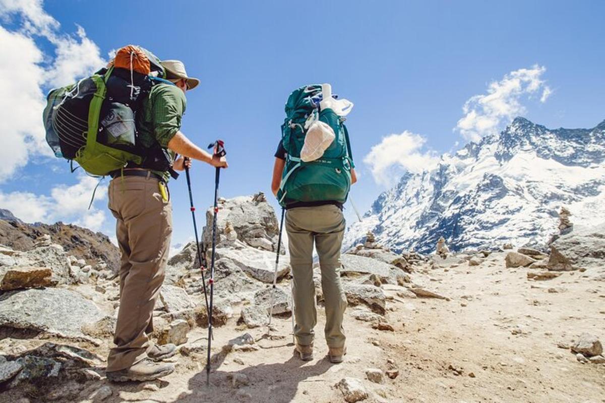 duas pessoas com mochilas no topo de uma montanha