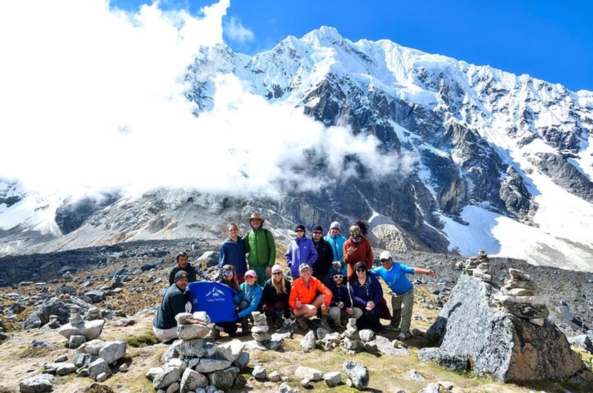 um grupo de pessoas posando em frente a uma montanha