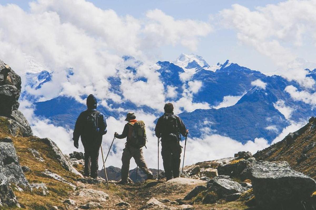 un grup de tres persones dretes al cim d'una muntanya