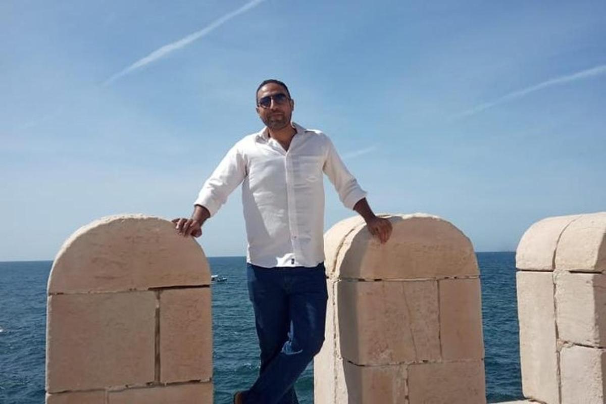 a man standing between two stone barriers near the ocean