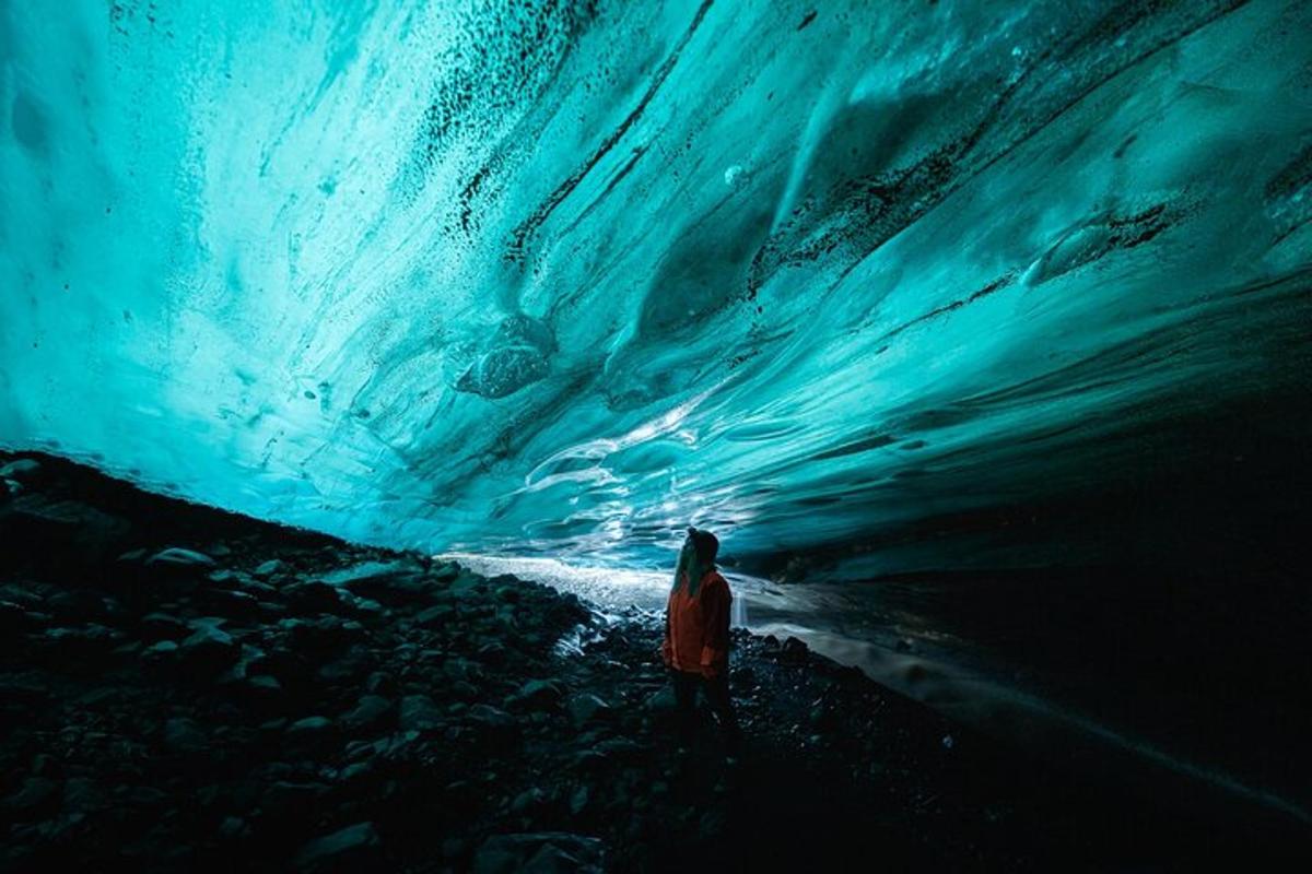 uma pessoa em pé em frente a uma caverna de gelo