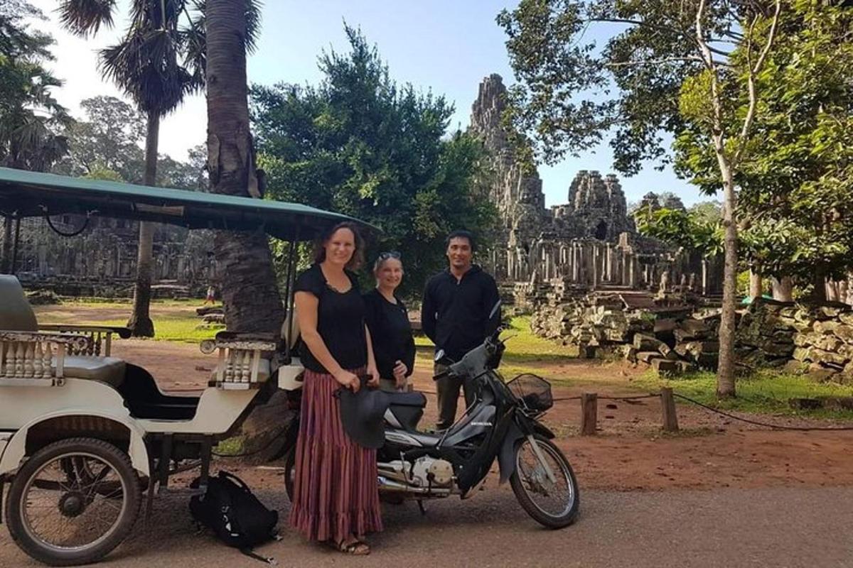 Un hombre y una mujer de pie junto a una motocicleta