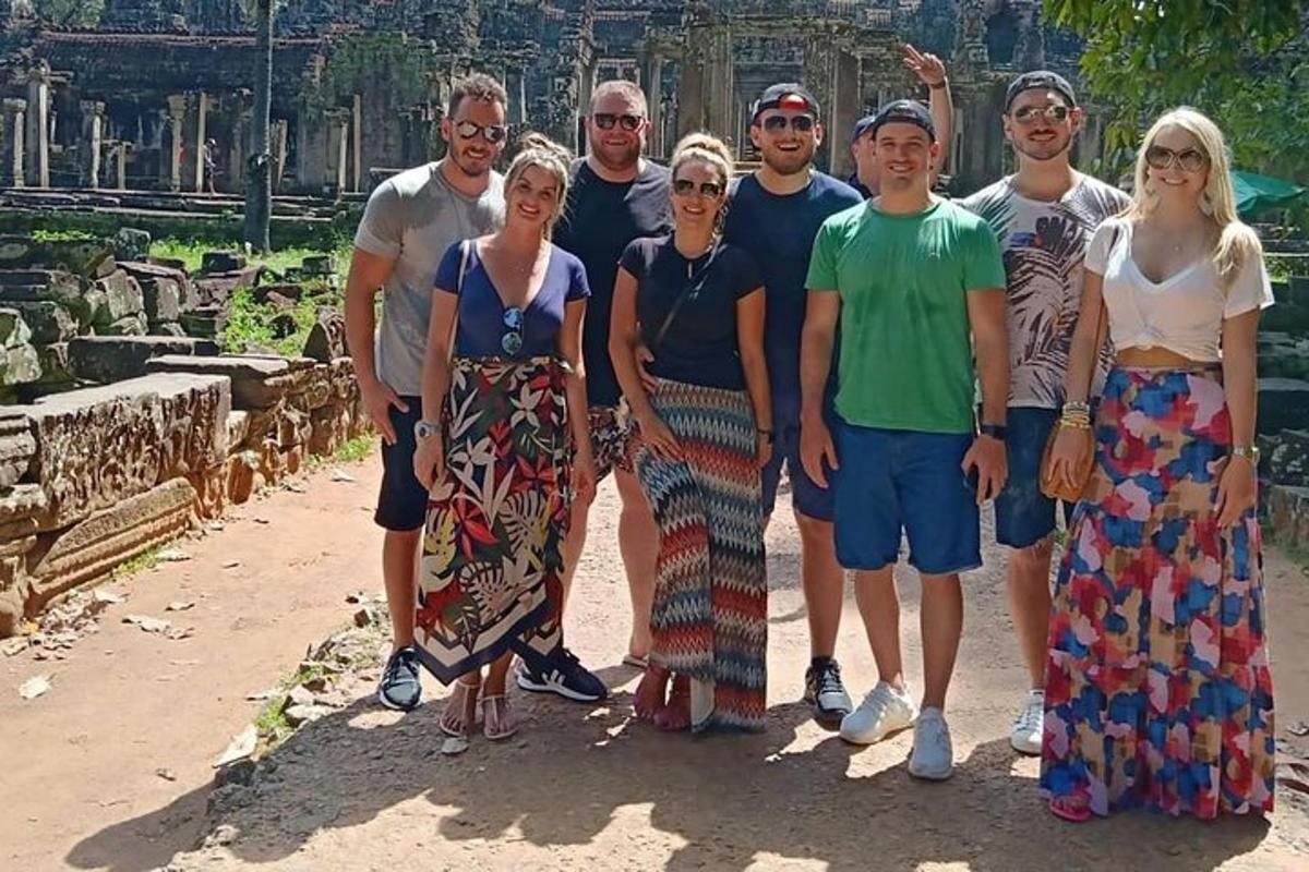un grup de oameni care pozează pentru o fotografie în fața unui templu