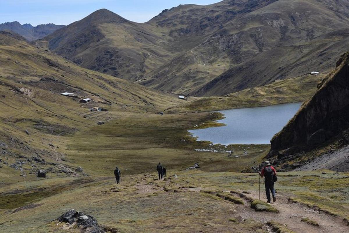 tiga orang berjalan di atas denai gunung berhampiran tasik