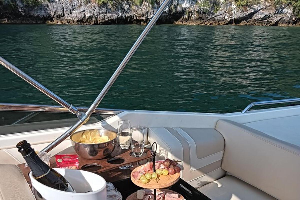 a table on a boat with a bottle of wine and food