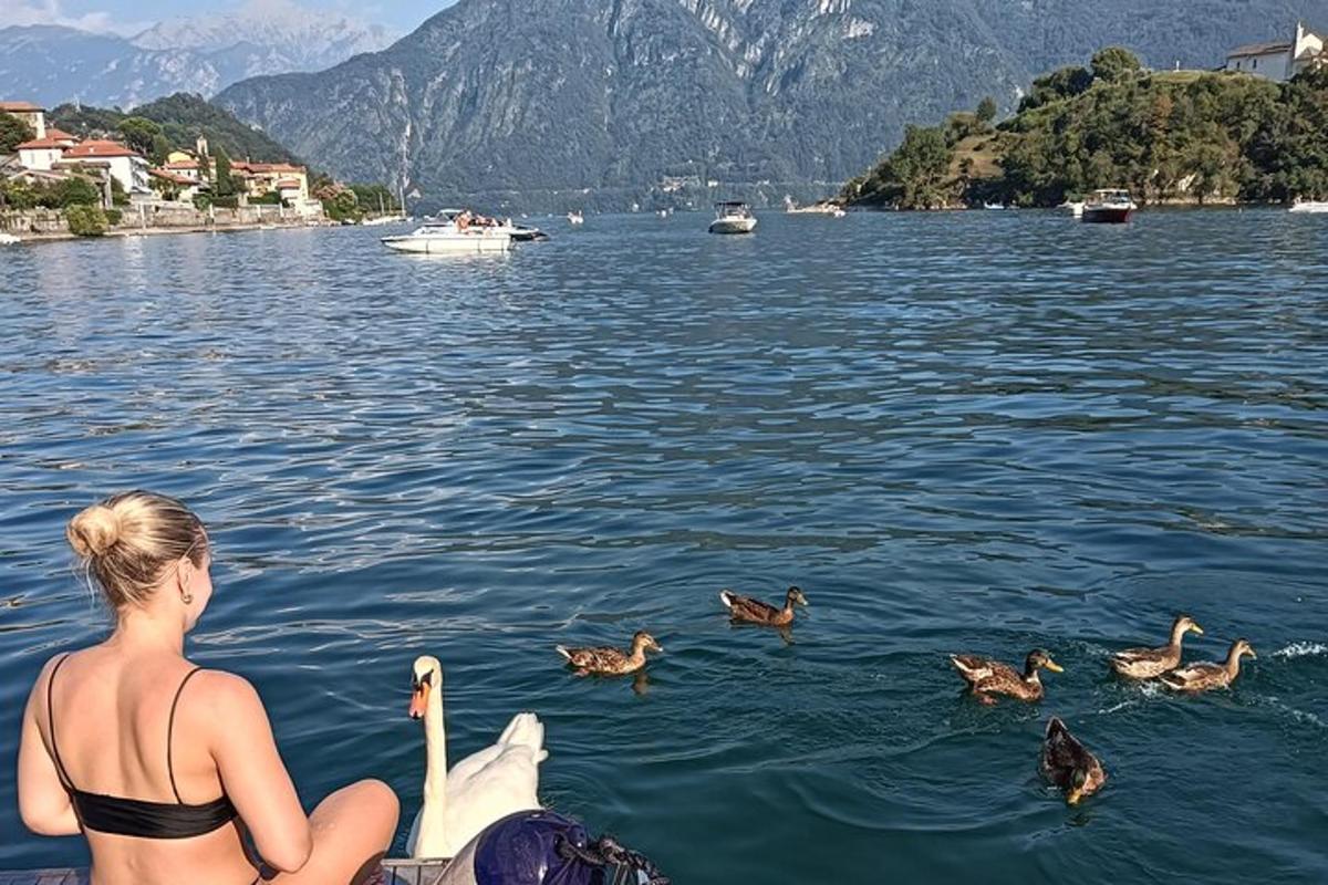una donna seduta su una barca che osserva le anatre nell'acqua