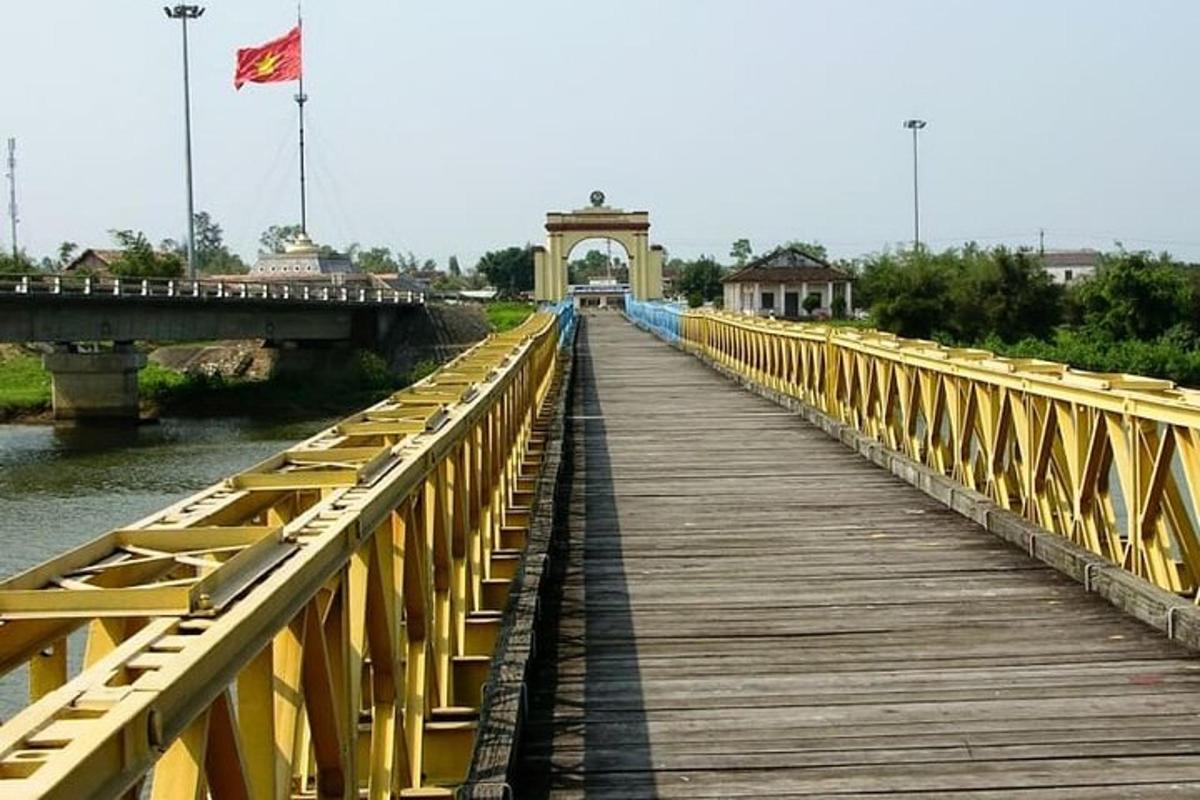 un ponte giallo sopra un fiume con una bandiera