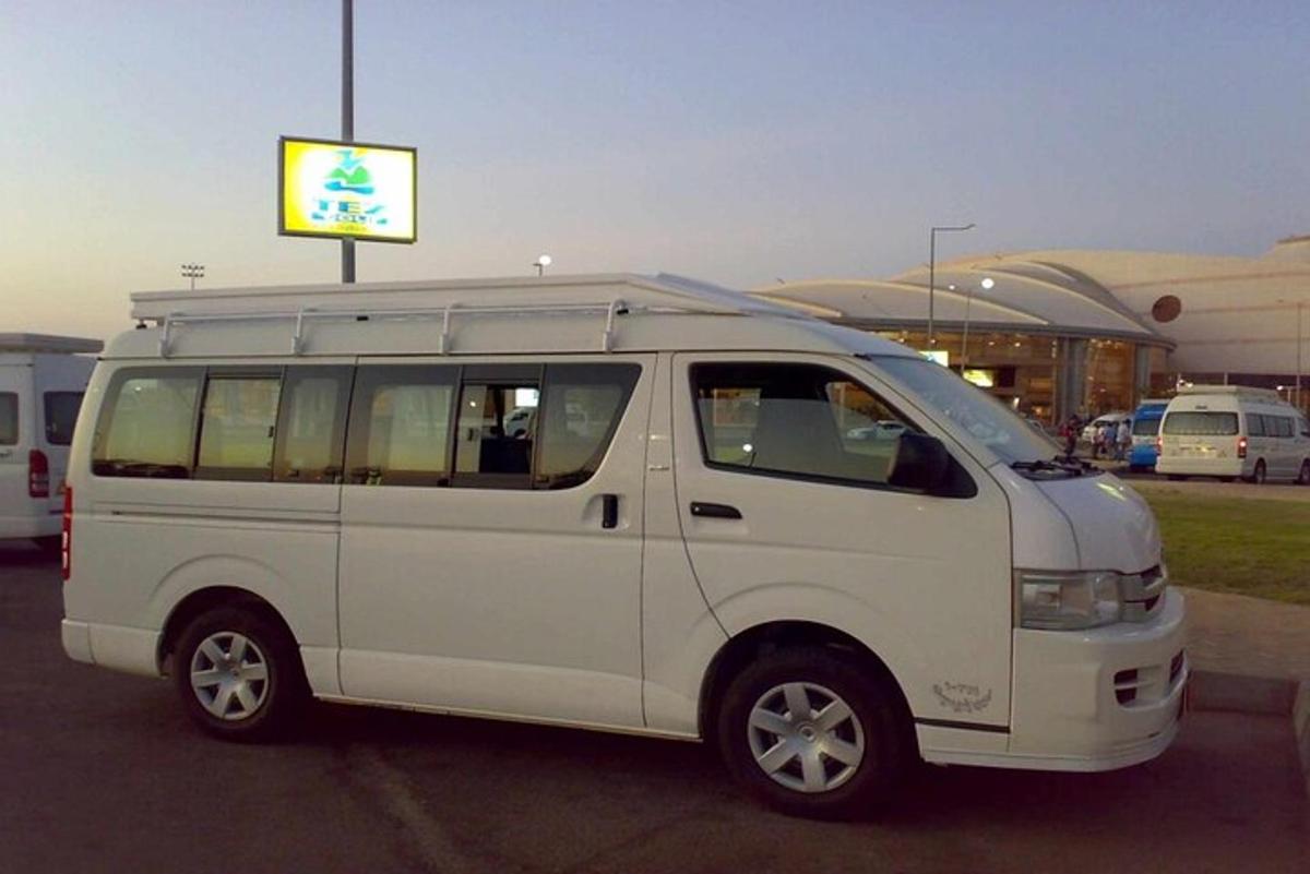 un furgone bianco parcheggiato in un parcheggio con un cartello