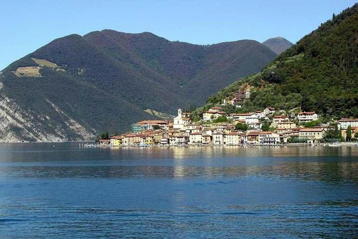 un poble a la vora d'un llac amb muntanyes