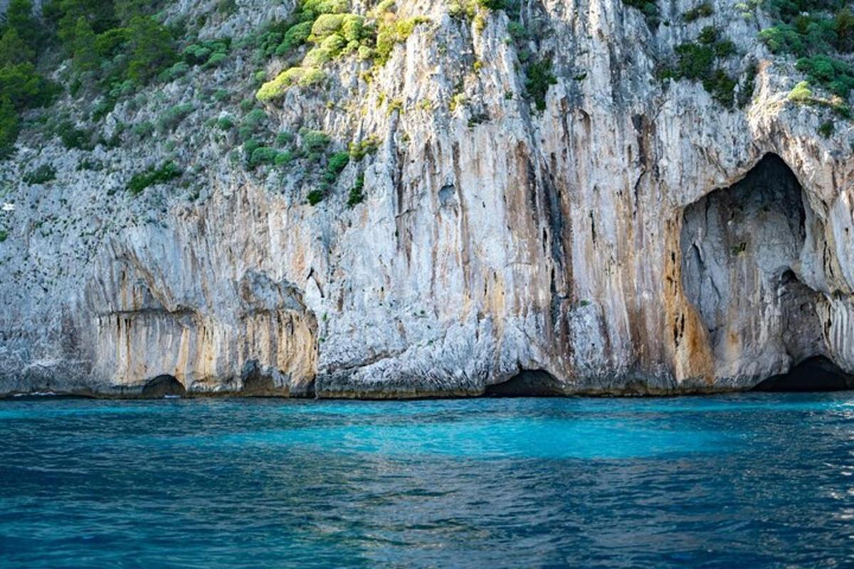tebing batu besar dengan air biru di hadapan