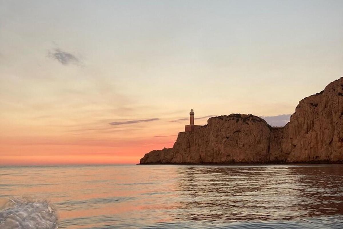 maják na útesu poblíž oceánu při západu slunce