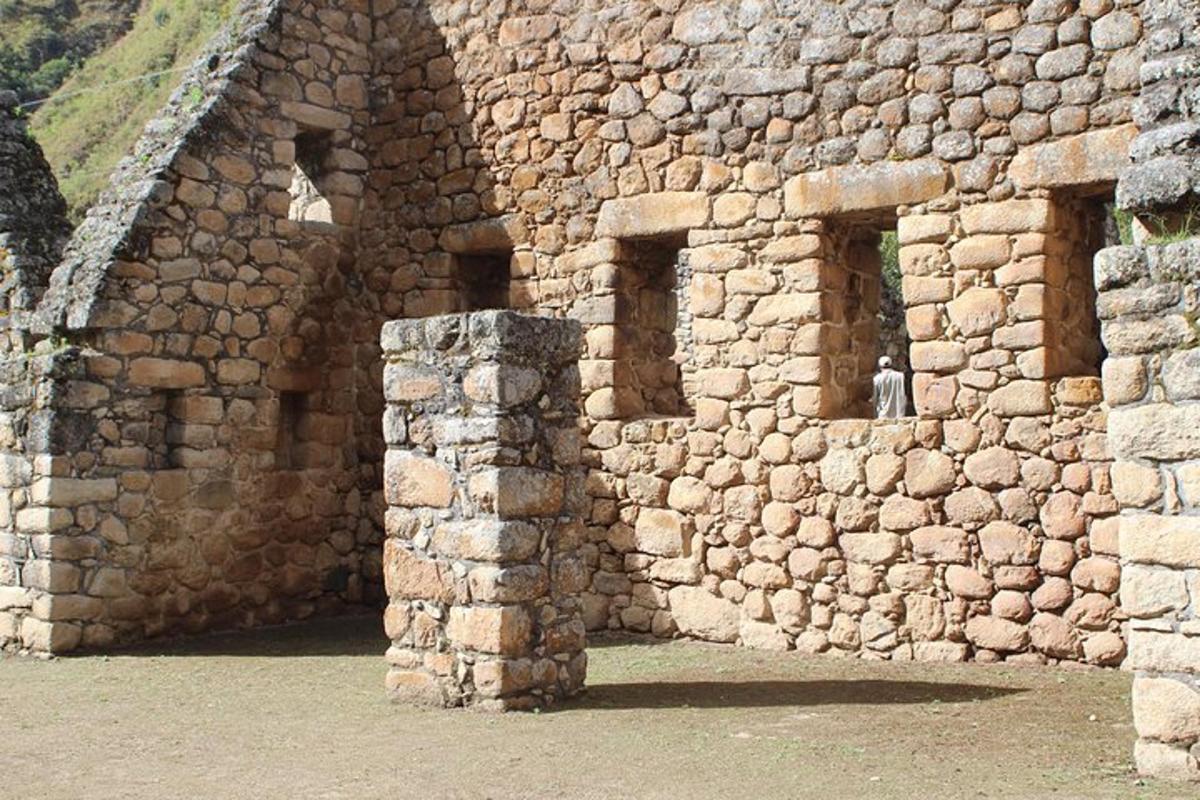 Un edificio de piedra con ventanas y un pilar de piedra.