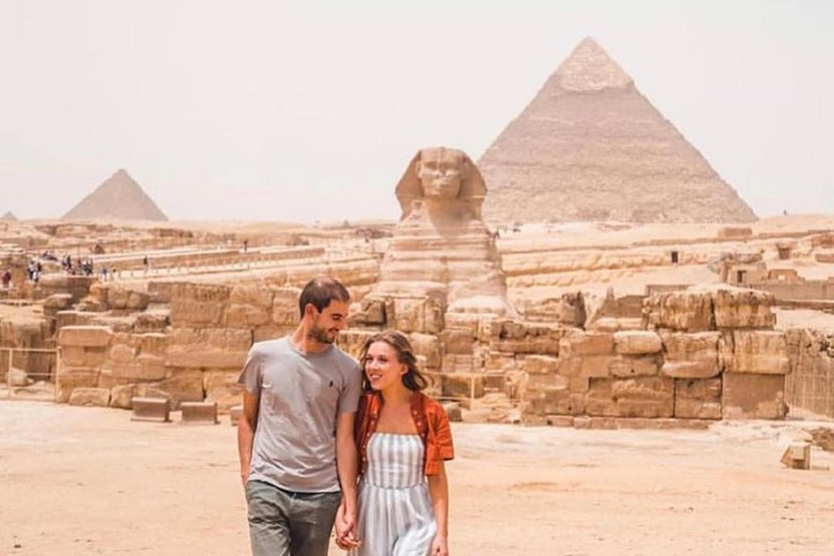 muž a žena stojící před pyramidami