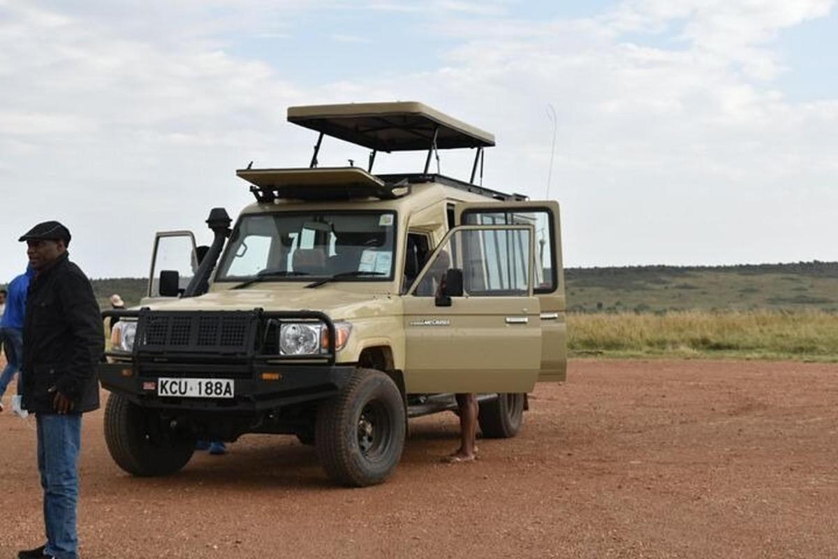 un uomo in piedi accanto a una jeep nel deserto