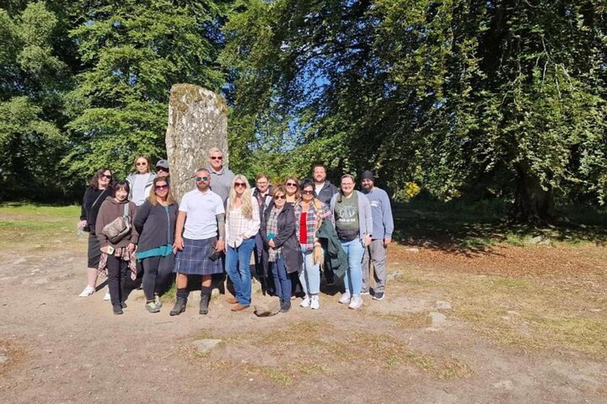 um grupo de pessoas posando para uma foto em frente a um monumento