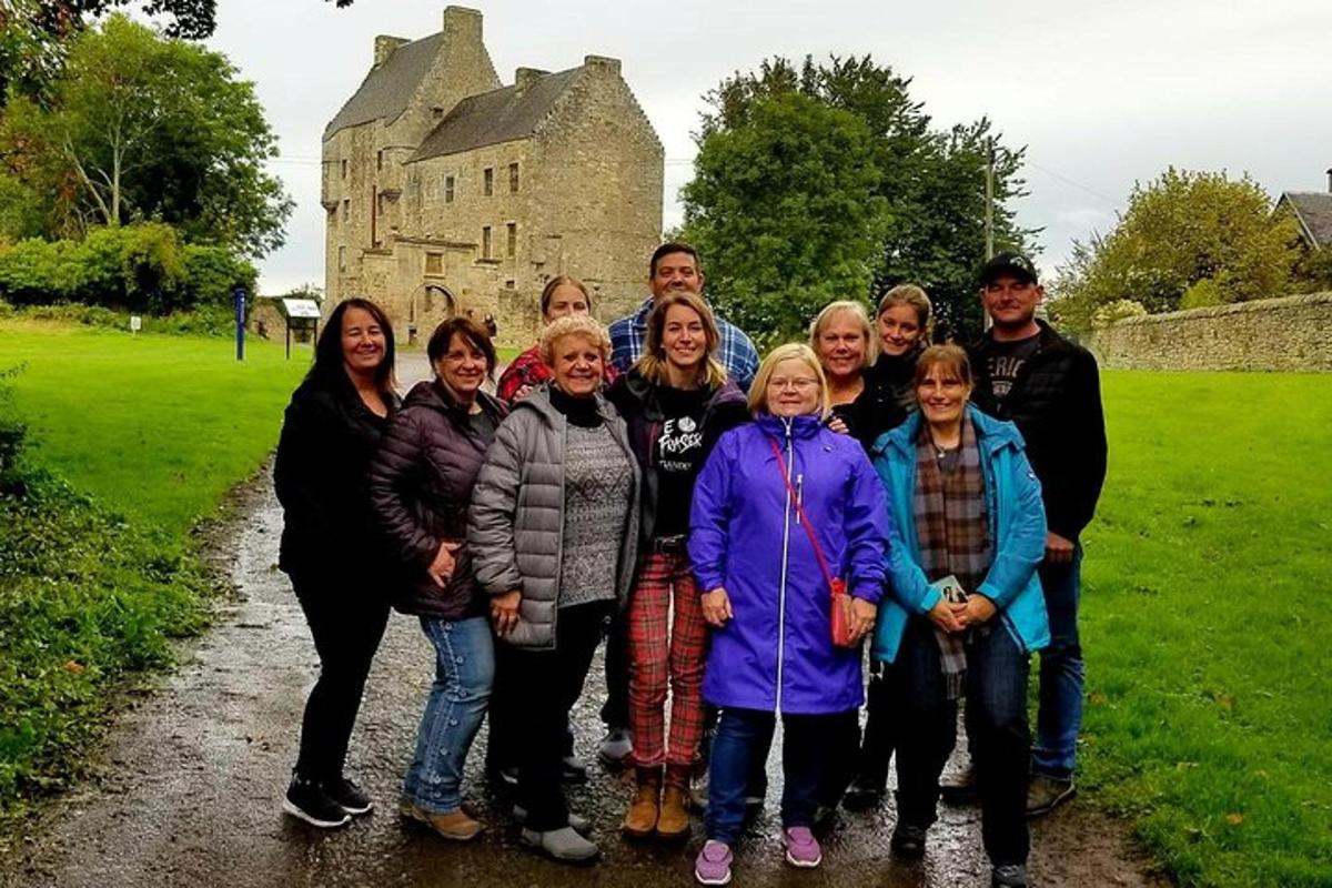 um grupo de pessoas posando para uma foto em frente a um castelo