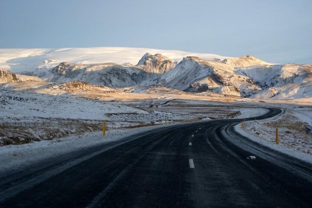 una carretera vacía en medio de una montaña nevada
