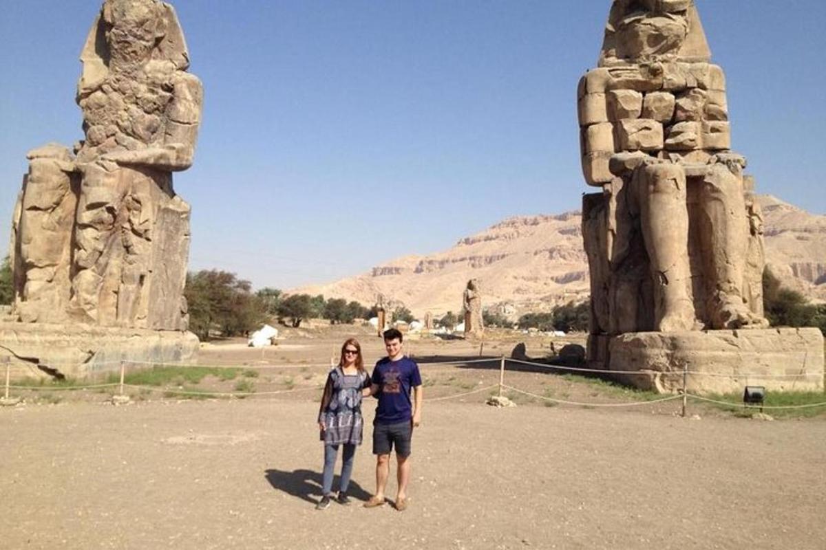 a man and a woman standing in front of a statue