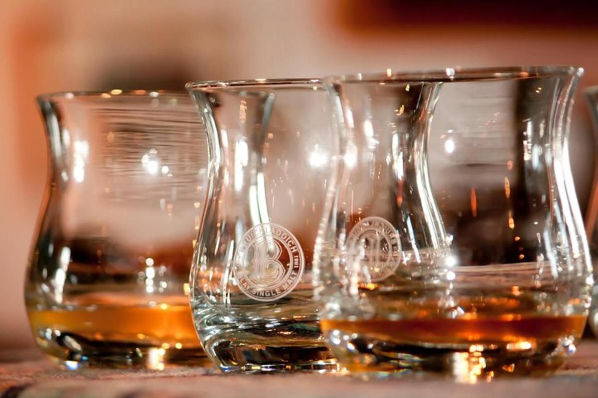tre bicchieri di whisky appoggiati su un tavolo