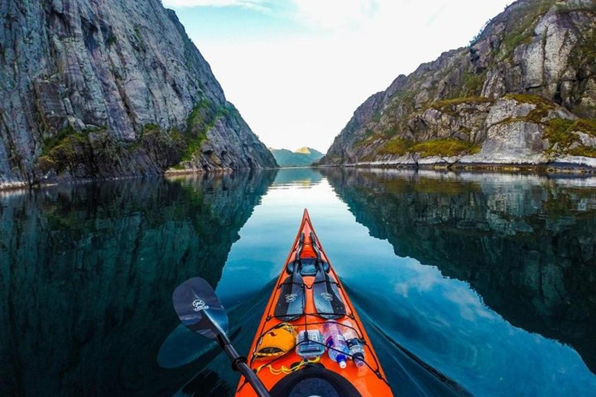 kayak oranye di danau di antara dua gunung
