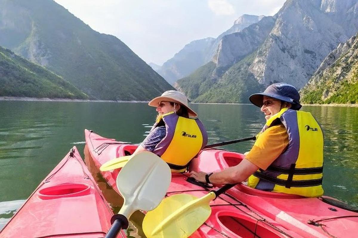 dua orang di kayak merah di danau