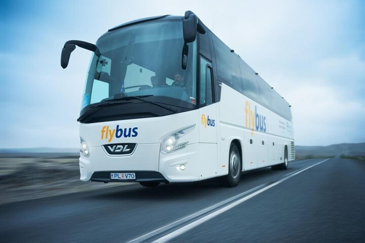 a white bus driving down a road