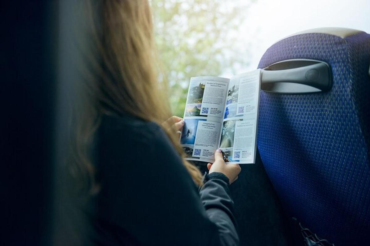 a woman reading a newspaper on a bus
