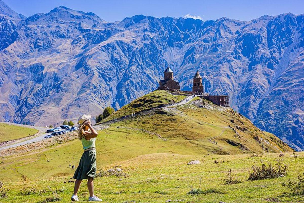 a woman standing on a hill looking at a castle