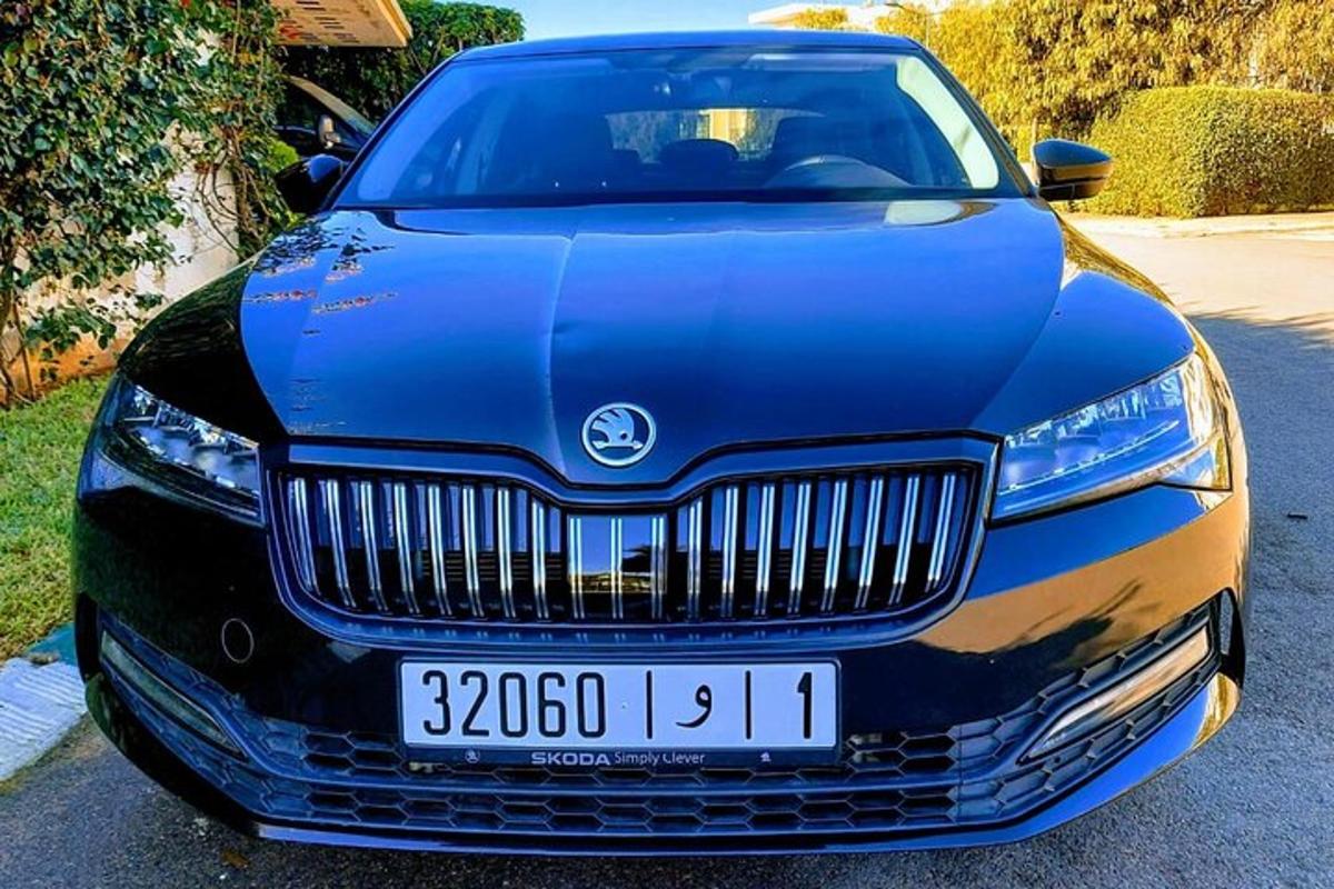 un cotxe blau està aparcat a l'entrada de casa