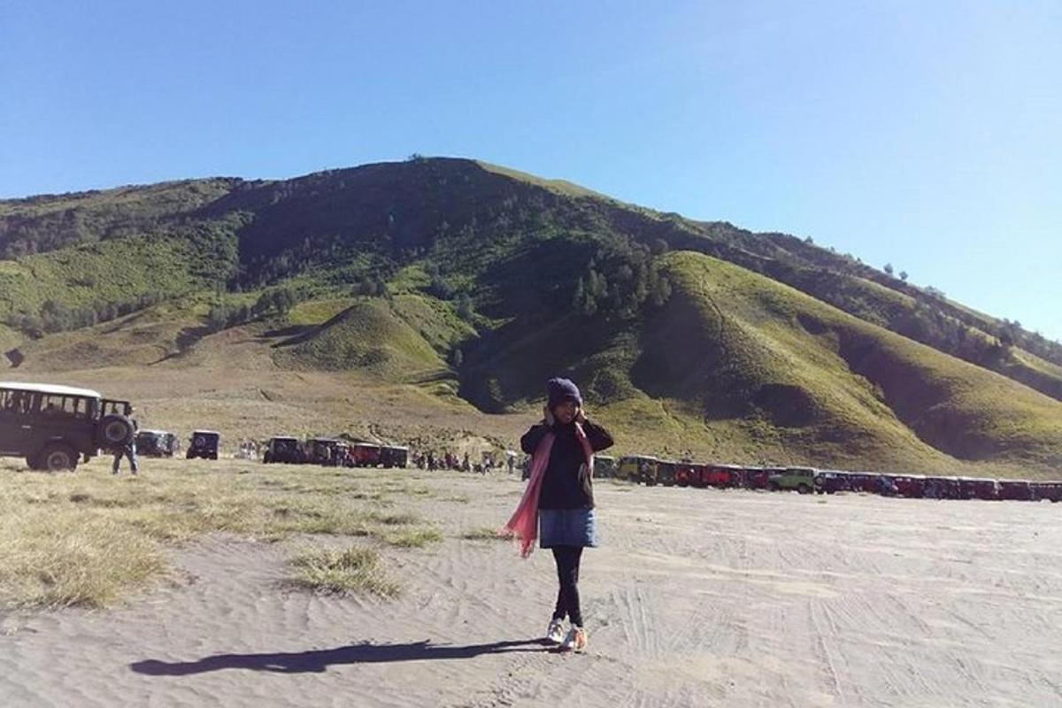 seorang wanita berdiri di atas pasir di hadapan sebuah gunung