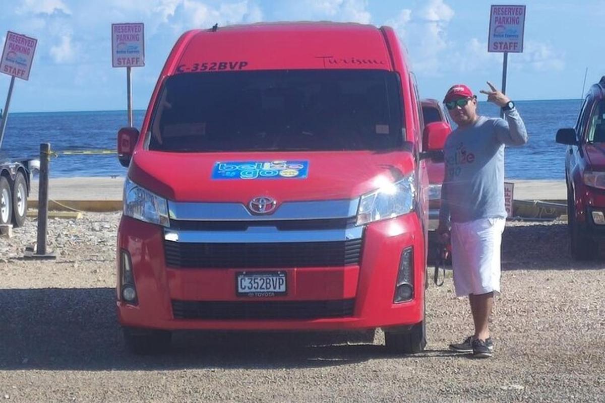 a man standing next to a red van on the beach