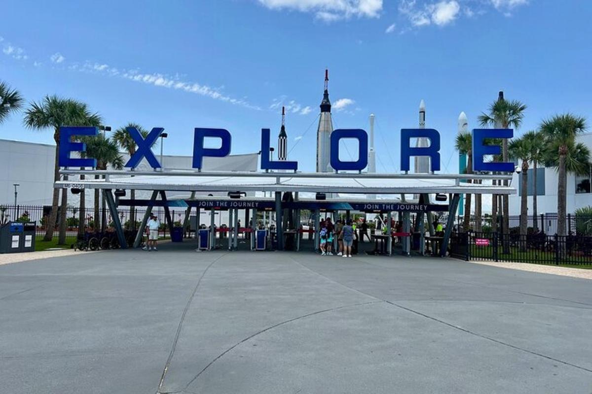 a large sign for a park with people standing outside
