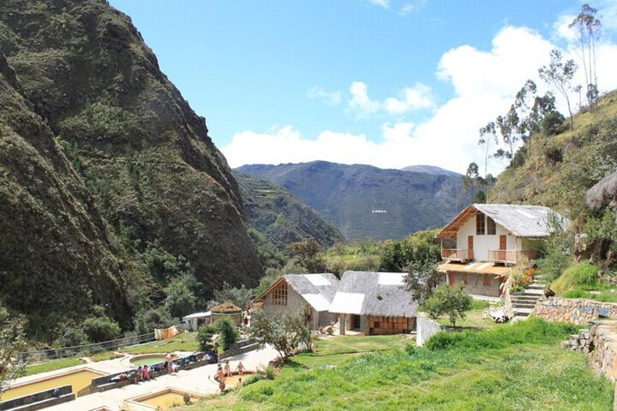 un villaggio in una valle con le montagne sullo sfondo