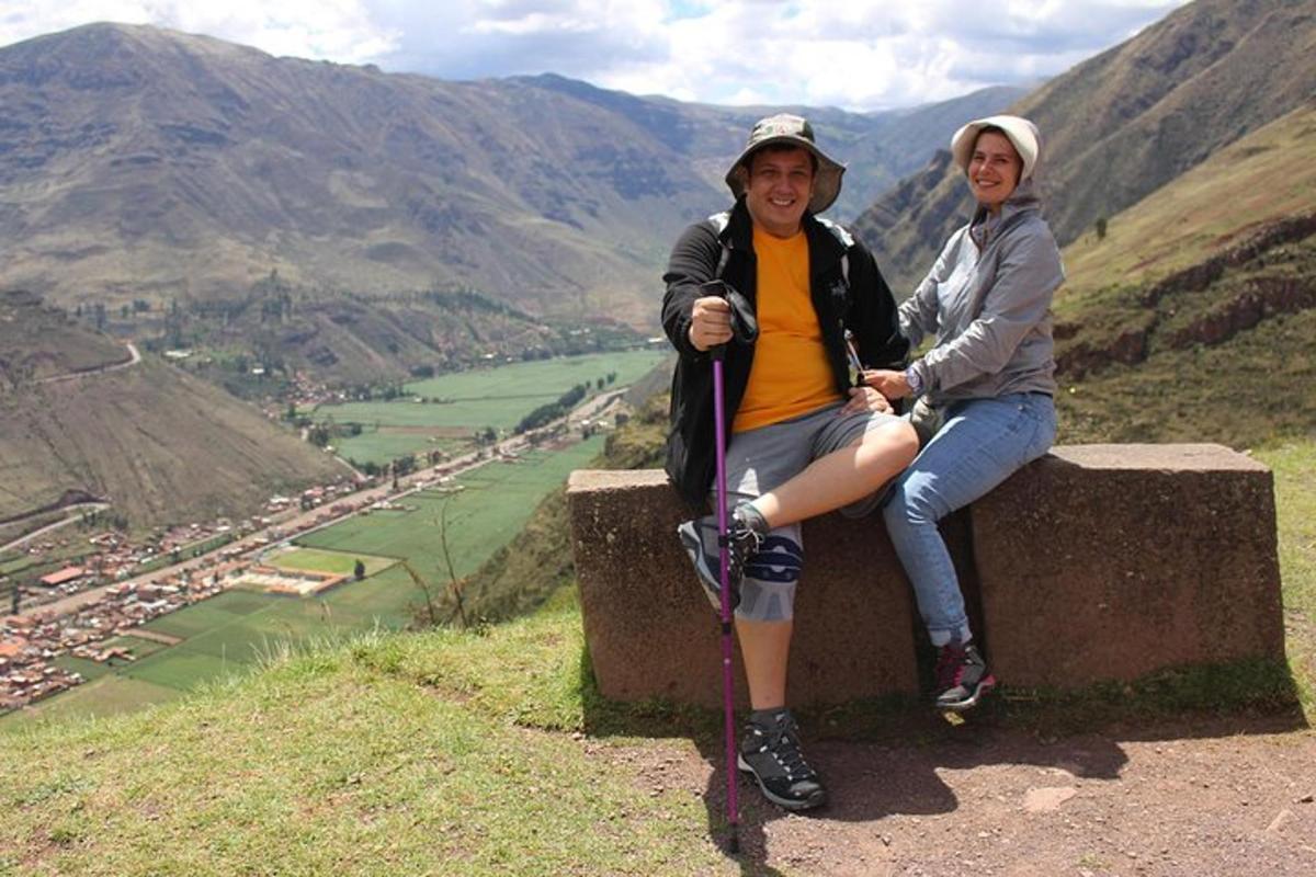 two people sitting on a ledge on a mountain