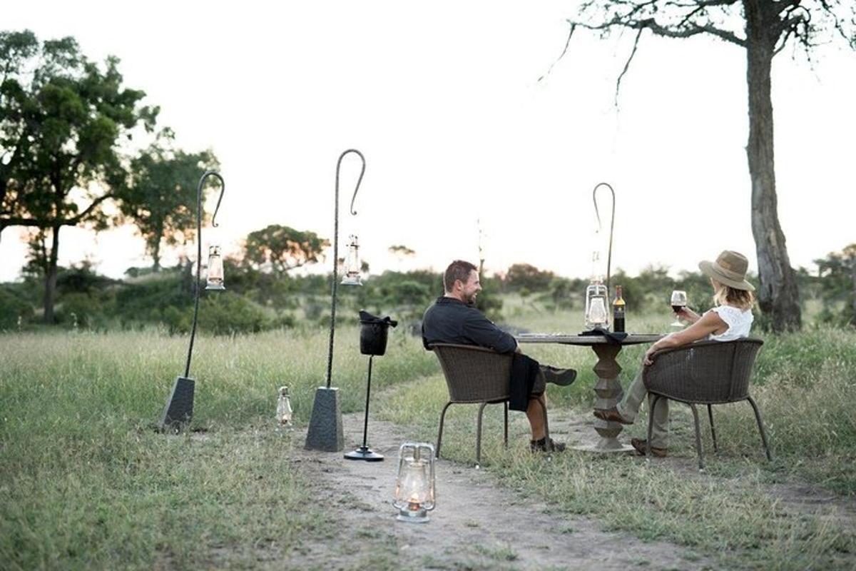 um homem e uma mulher sentados à mesa em um campo
