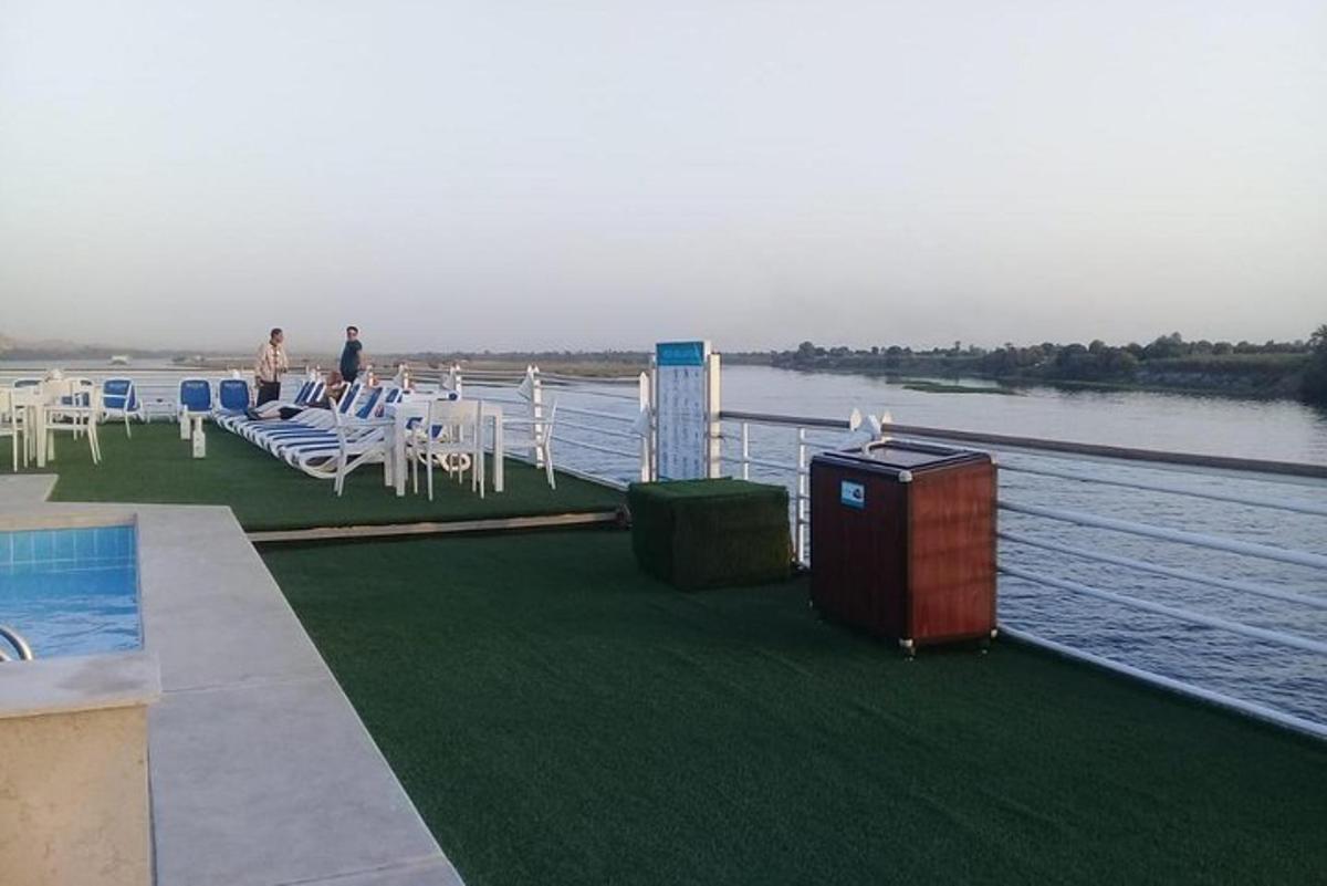un grup de mese și scaune pe un doc lângă apă