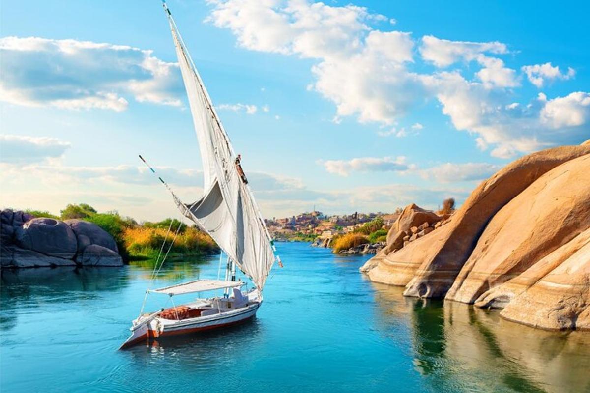 um barco com uma vela branca em um rio