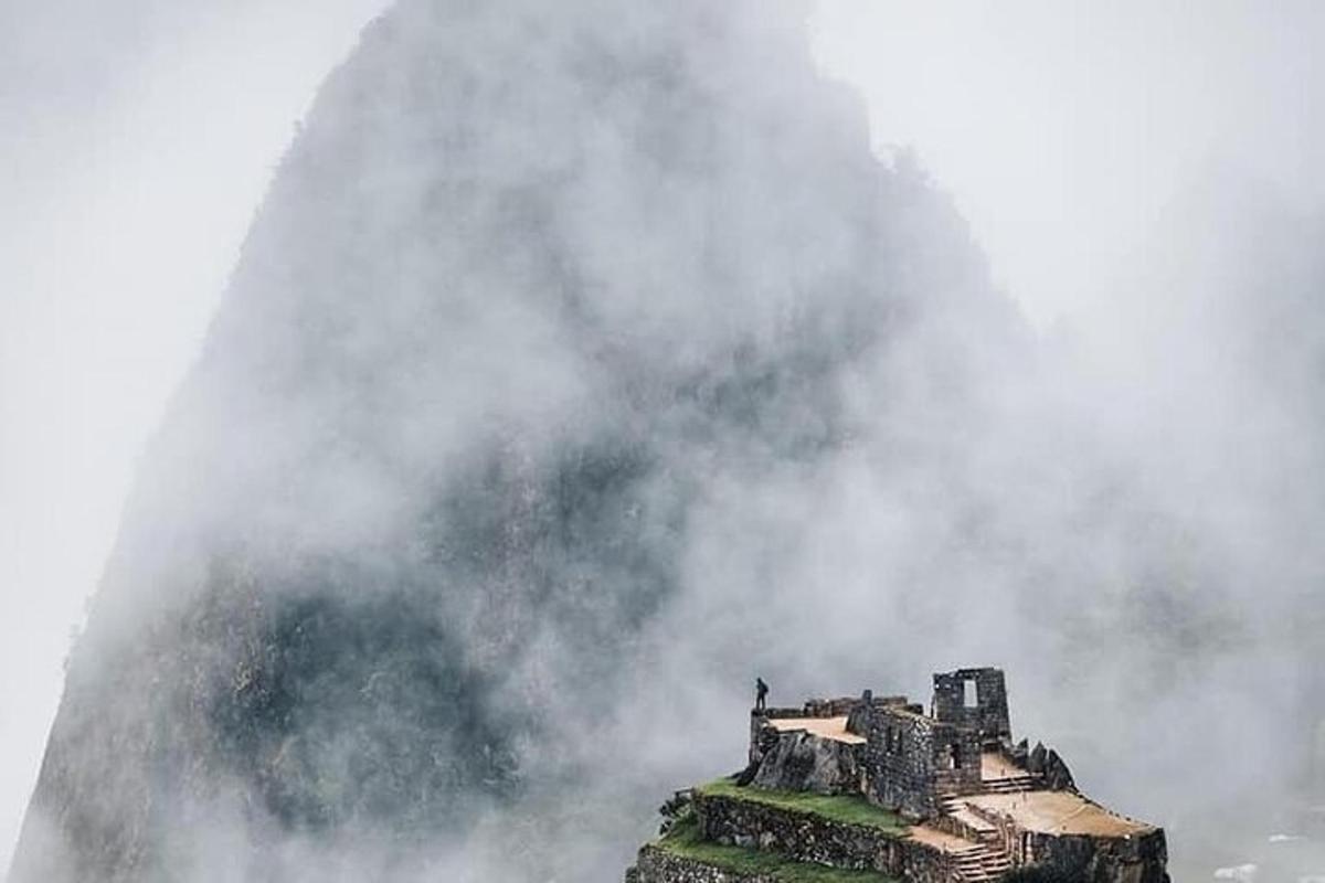 a building in the mist with a fountain in the background