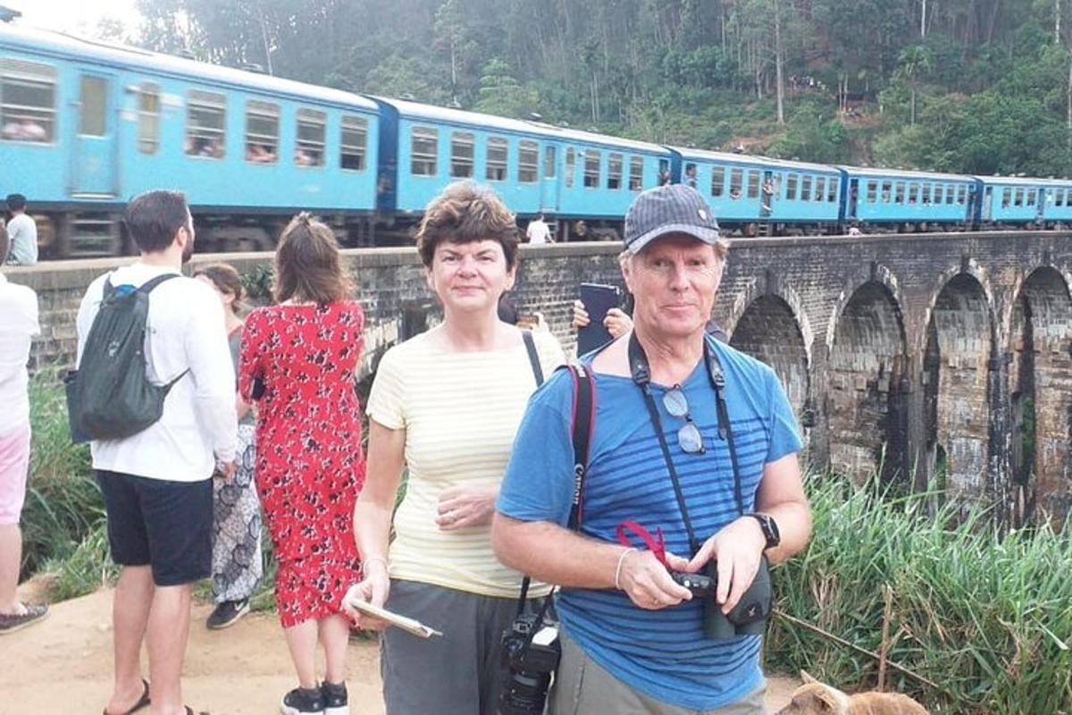 a man and a woman standing in front of a train