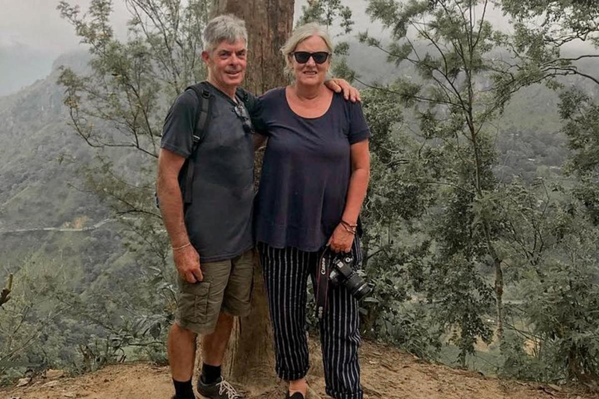 un uomo e una donna in piedi sulla cima di una montagna