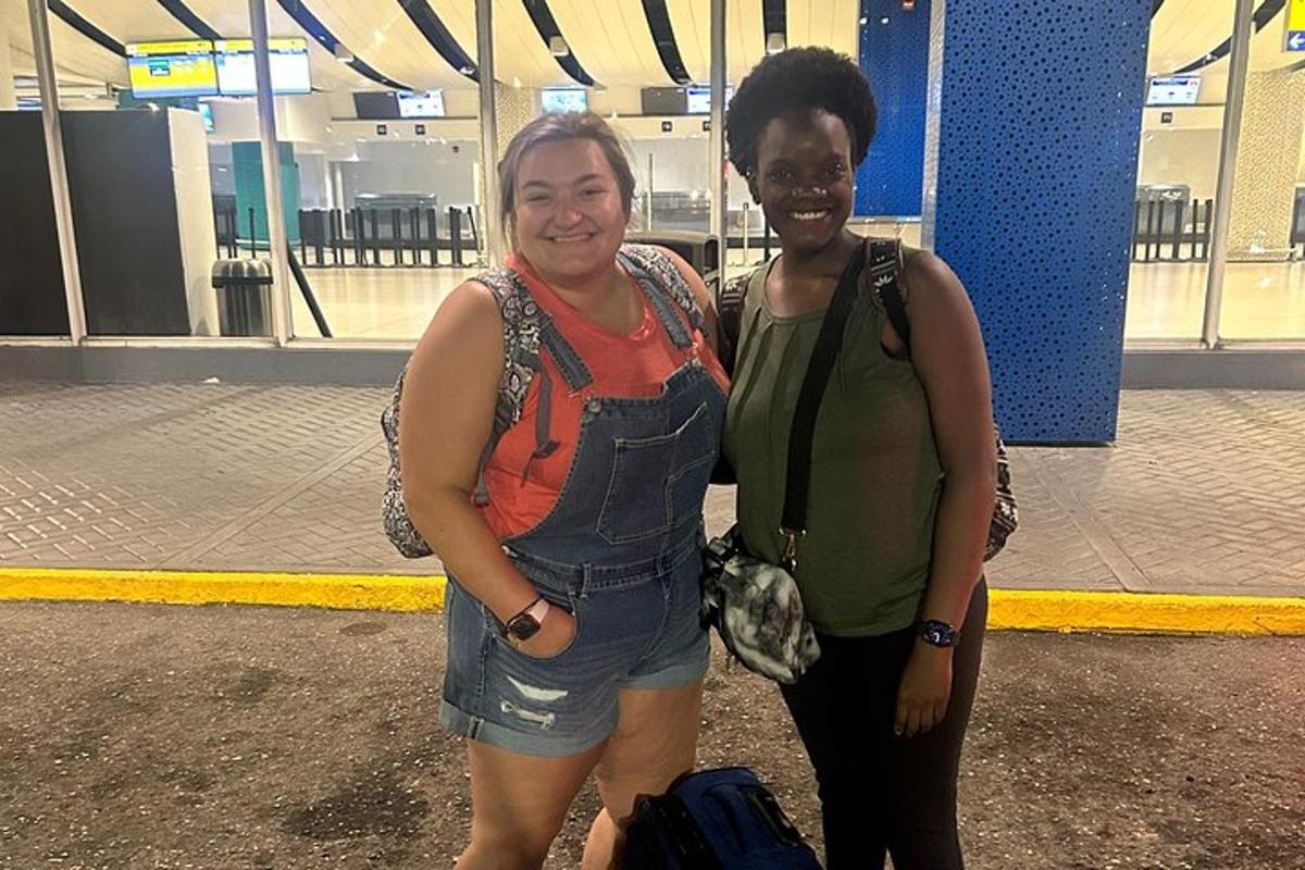 Dos mujeres paradas una al lado de la otra en un aeropuerto