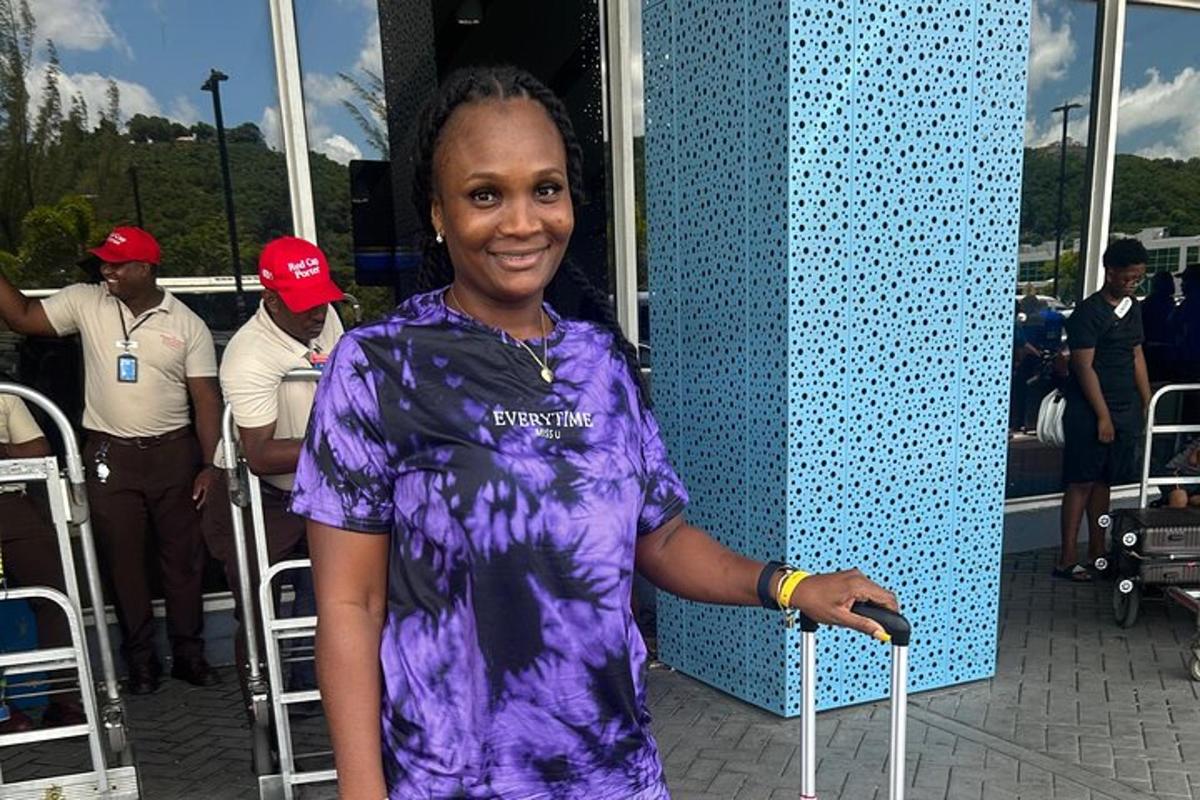 una dona amb camisa morada que sosté una maleta