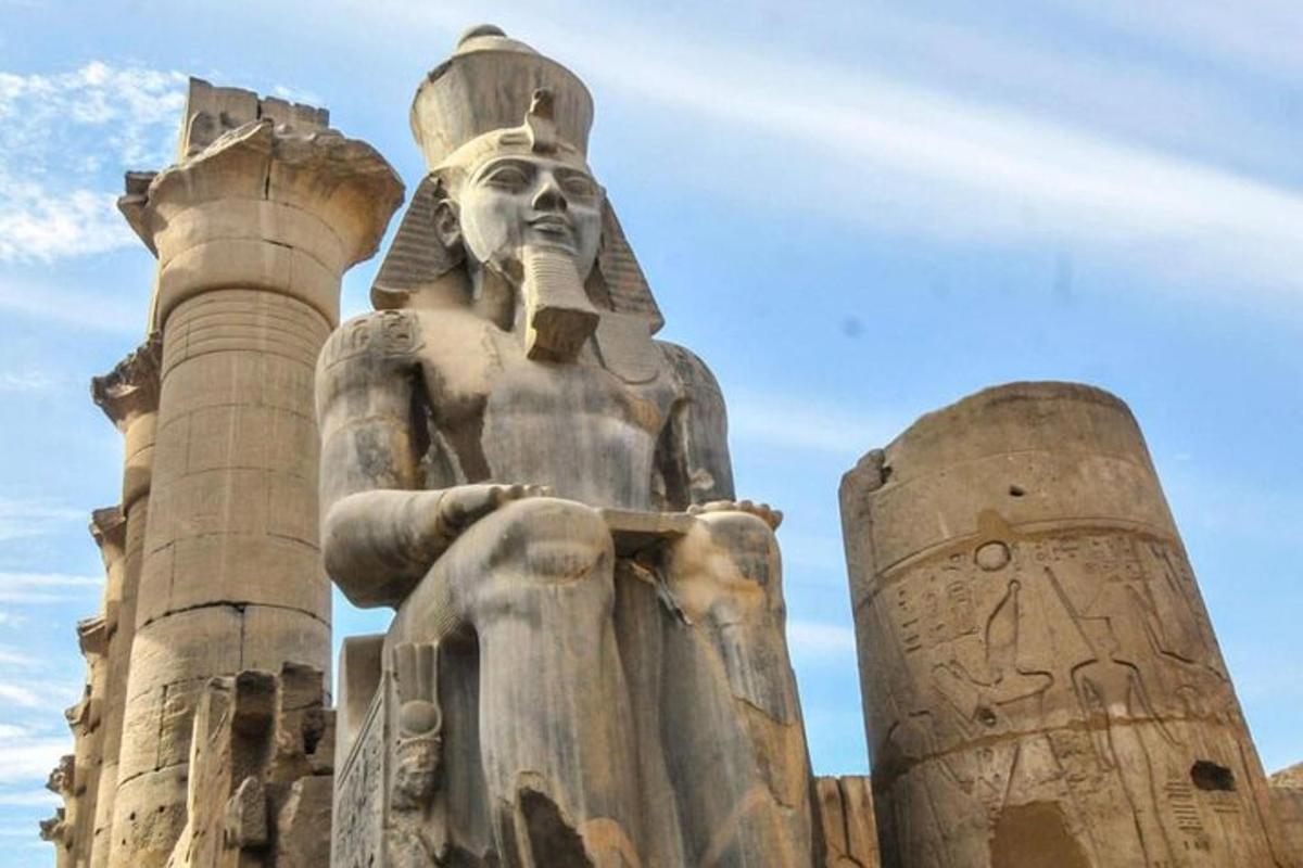 Una gran estatua de Aaraoh de pie frente a él.